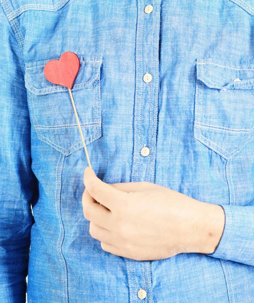 Real love concept. Man holds little red heart and shows his genuinely, real love