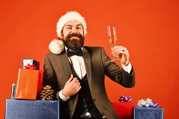 Hombre con barba sostiene champán sobre fondo rojo. — Foto de Stock