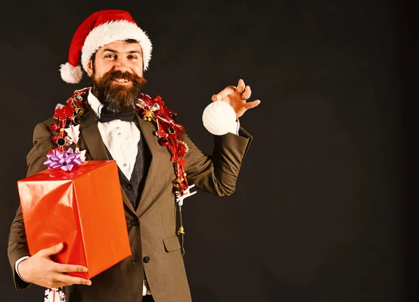 Man in smart suit, Santa hat and garlands on brown