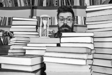 Zaman akışı kavramı. Öğretmen ya da sakal Kitaplığı'nda eğitim ile öğrenci. Dostum, bilim adamı bardaklarda kum saati görünüyor. Adam şaşırmış yüzündeki eğitim, kitap rafı arka plan üzerinde iken kum saati oturur