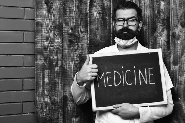 ひげそり残忍なcaucasian医師保持ボードとともに医学碑文 — ストック写真