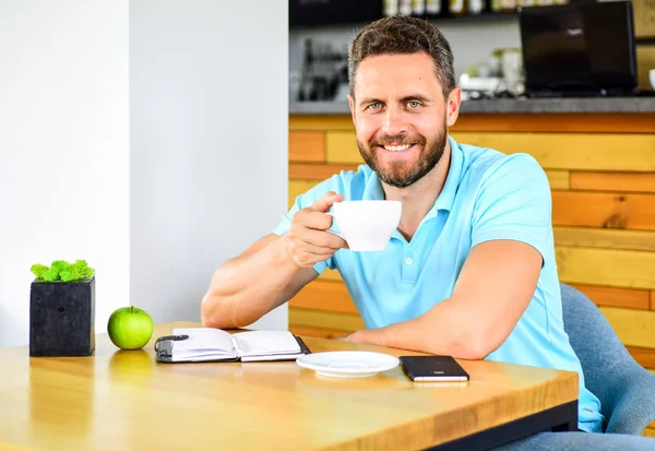 Healthy habits. Healthy man care vitamin nutrition during working day. Physical and mental wellbeing concept. Man sit eat green apple fruit. Coffee and fruit recharge energy reserve. Healthy snack