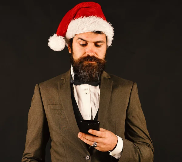 Manager with beard types message on cell phone.
