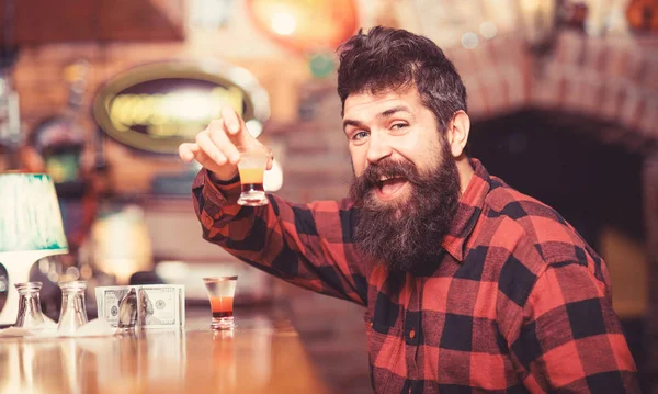 Hipster holds glass with alcoholic drink, short cocktail.