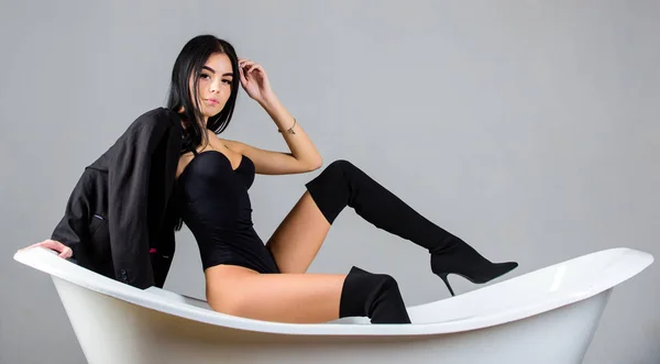 Donna sexy ragazza gambe lunghe indossare stretto bustier body e tacchi alti. Ragazza rilassato posa sexy magra sulla vasca da bagno. Sentirsi sexy concetto attraente. Moda sexy splendida modella seducente posa sulla vasca da bagno — Foto Stock