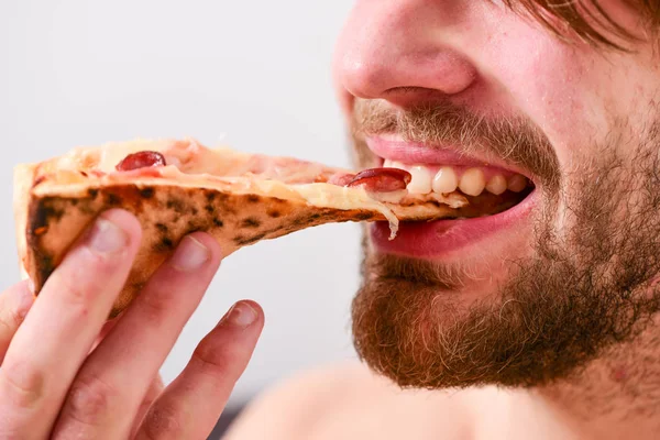 Jovem faminto em roupa interior senta-se em casa em uma cama com uma caixa de pizza. Quebre o conceito de dieta. Serviço de entrega de alimentos. Pizza em casa . — Fotografia de Stock