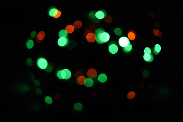 节日背景与五颜六色的灯光。即将到来的假期的明亮和节日气氛。圣诞装饰品的概念。五颜六色的花环的失速。抽象五颜六色的 bokeh 背景 — 图库照片