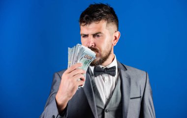 Zenginlik ve refah kavramı. Nakit para kolay ve hızlı bir şekilde almak. Para gibi kokuyor. Kolay nakit krediler. Resmi takım elbise mavi arka plan doları banknot yığını tutun. İşadamı nakit para var.
