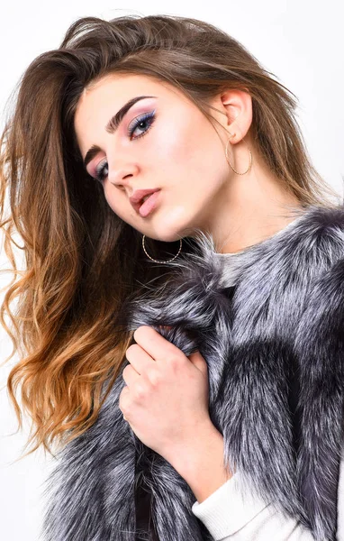 Luxury fur accessory. Fashion trend concept. Winter fashionable wardrobe. Silver fur vest fashion clothing. Boutique selling fur. Girl makeup face long hairstyle wear fur vest white background
