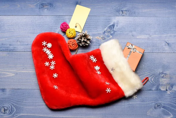 Celebrate christmas. Contents of christmas stocking. Small items stocking stuffers or fillers little christmas gifts. Christmas sock toned wood background top view. Fill sock with gifts or presents