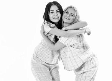 Kızlar sıkı, izole üzerinde beyaz arka plan sarılma. Kız kardeşim en iyi arkadaş kavramı. Kız ya da arkadaşlarım pijama. Sarışın ve esmer gülümseyen yüzler uyku giysileri üzerinde şirin ve samimi görünüyor