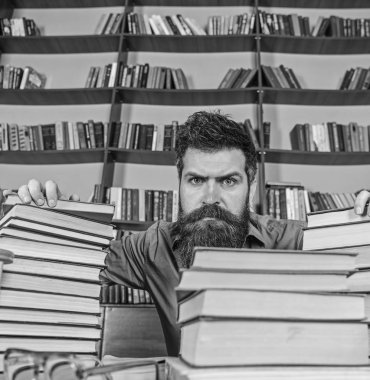 Öğretmen ya da öğrenci sakallı defocused gözlük ile masada oturur. Adam Kitaplığı'nda, eğitim sırasında kitaplar, kitap rafı arka plan üzerinde yığınları arasında sıkı yüzünde. Kazık kavramı