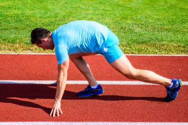 Zafer için çaba. Adam atlet runner standı düşük başlangıç pozisyonu stadyum yolu. Runner gitmeye hazır. Yetişkin runner yarış Stadyumu'nda hazırlayın. Nasıl yayınlanmaya başlaması. Profesyonel atlet spor ipuçları