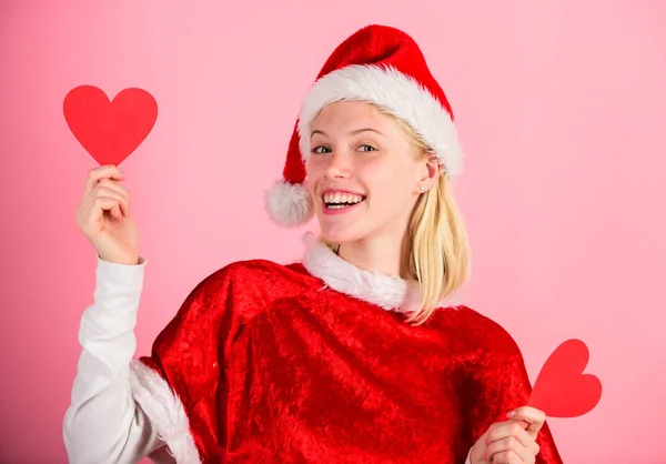 Chica enamorada traje de Santa Claus feliz celebrar la Navidad fondo rosa. Feliz Navidad y feliz año nuevo. La mujer tiene el corazón símbolo del amor. Trae amor a las vacaciones familiares. Difundir amor alrededor — Foto de Stock