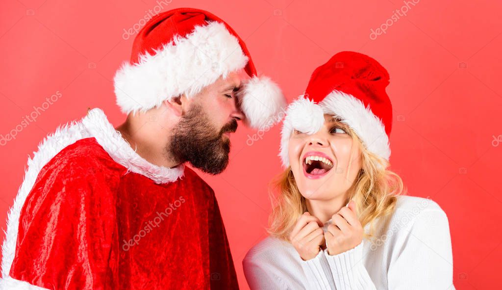 Man with beard and woman santa hat red background. Couple cheerful face celebrate christmas. Rent santa costume. Couple celebrate winter holiday christmas party. Christmas masquerade karnival concept