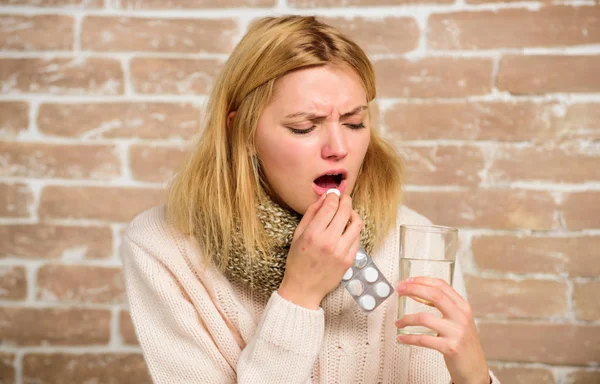 Headache and fever remedies. Woman tousled hair scarf hold glass water and tablets blister. Take medications to reduce fever. Girl feels ill suffer fever and take medicine. Pills for breaking fever — Stock Photo, Image