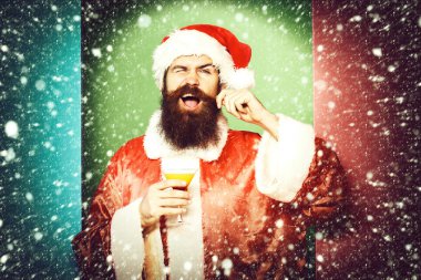 Yakışıklı, sakallı, uzun sakallı, komik sakallı Noel Baba Noel 'de elinde bir bardak alkollü içecek ya da Noel süveteri ve renkli stüdyo geçmişinde yeni yıl şapkası tutan adam.