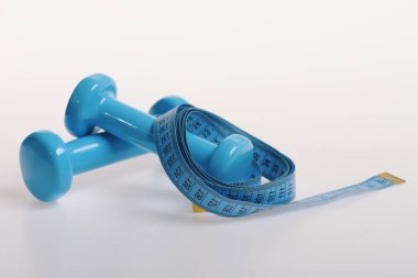 Beyaz arkaplanda mavi plastikten yapılmış dambıllar