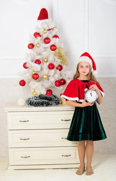 Last minute till midnight. Last minute new years eve plan. Merry christmas concept. New year countdown. Girl kid santa hat costume hold clock excited happy face expression counting time to new year