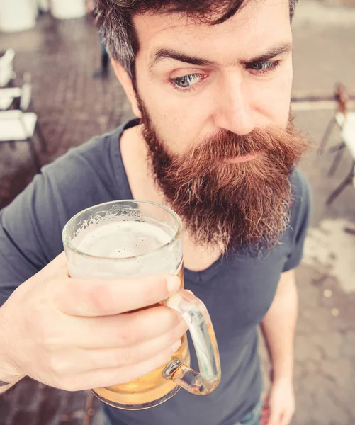 Kille med resten med kall fatöl. Fatöl koncept. Mannen med skägg och mustasch innehar glas med öl medan du kopplar av på kaféterrassen. Hipster på strikt ansikte dricka öl utomhus — Stockfoto