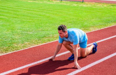 Nasıl yayınlanmaya başlaması. Profesyonel atlet spor ipuçları. Adam atlet runner standı düşük başlangıç pozisyonu stadyum yolu. Zafer için çaba. Runner gitmeye hazır. Yetişkin runner hazırlamak Stadyumu at yarışı