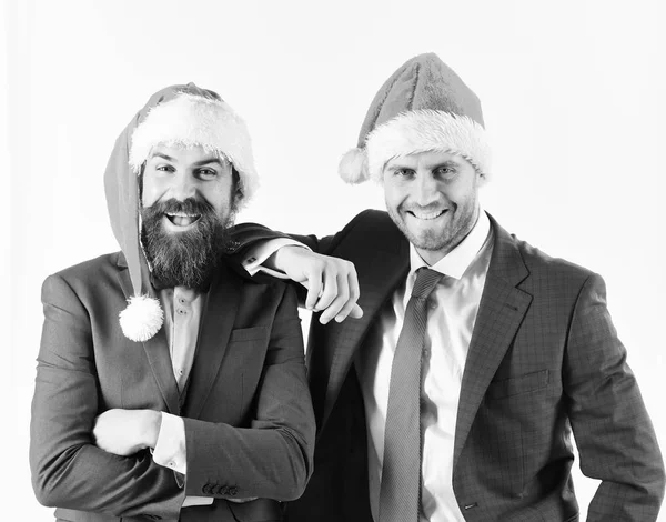 Muži v chytrých oblecích a Santa klobouky na bílém pozadí — Stock fotografie