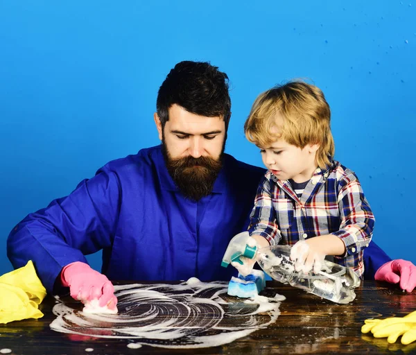 Concepto de actividades de limpieza. Hombre con lindo niño sobre fondo azul . — Foto de Stock
