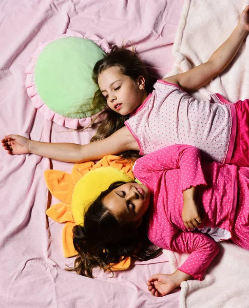Fiesta de pijama y concepto de infancia. Las niñas se acuestan en las sábanas — Foto de Stock