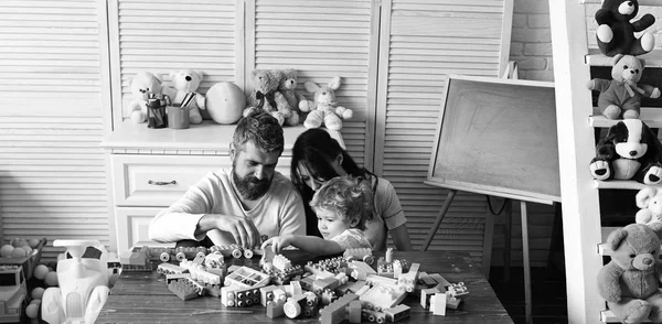 Familie en kindertijd concept. Jonge familie brengt tijd door in de speelkamer — Stockfoto