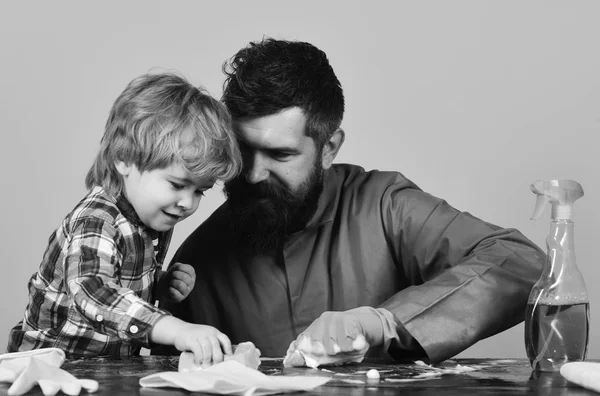 Hijo y padre con caras sonrientes cerca de aerosoles y guantes . —  Fotos de Stock