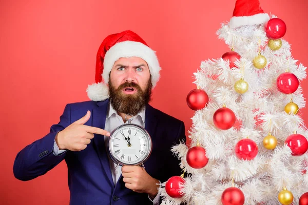 Čas na oslavu. Muž vousatý opotřebení oblek a santa klobouk drží hodiny. Podnikatel se vánoční oslavu. Last minute nabídky. Počítání času do Vánoc. Kolik času zbývá. Mějte přehled o čase — Stock fotografie
