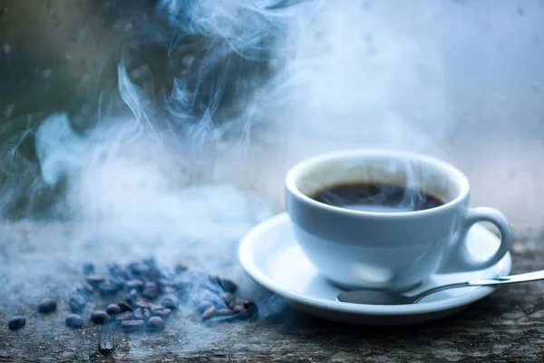 コーヒーの朝の儀式。新鮮な醸造コーヒー ホワイト マグカップと窓辺の豆。ガラス窓とホット コーヒーのカップに濡れています。秋の曇り天気カフェイン飲むと良い。雨の日にコーヒーを楽しむ — ストック写真