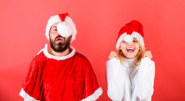 Noel kavramı maskeli balo ya da karnival. Çift neşeli yüzü Noel kutlaması. Çift kutlamak kış tatil Noel partisi. Sakal ve santa şapka ponpon kırmızı arka plan ile kadında olan adam