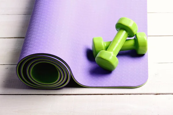 Sports and healthy lifestyle concept. Barbells on purple yoga mat