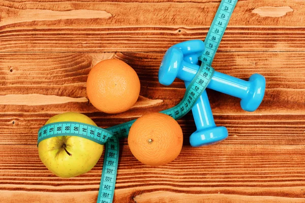 Γυμναστήριο και την υγεία έννοια, αλτήρες βάρος με μεζούρα, φρούτα — Φωτογραφία Αρχείου