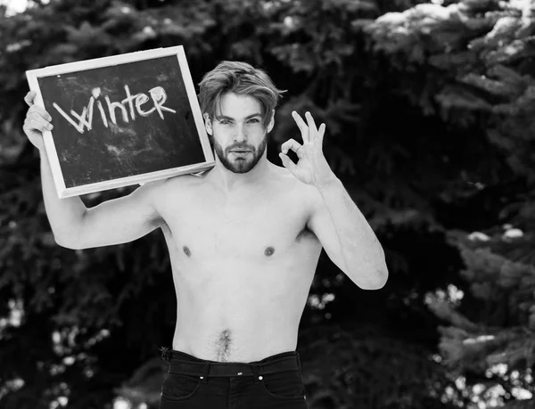 Handsome muscular man with winter blackboard outdoor — Stock Photo, Image