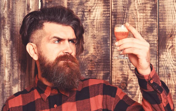Mężczyzna trzyma koktajl alkoholowy na drewnianym tle. — Zdjęcie stockowe