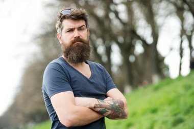 Gözlüklü sakallı adam. Hipster emin tutun çarpı işareti kollar göğüs üzerinde sakallı. Sakallı hippi acımasız maço. Kuaför kavramı. Bıyık ciddi bir yüz emin doğa arka plan ile sakallı adam