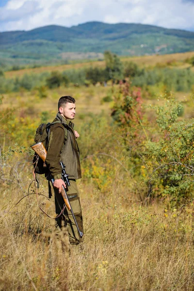 Temporada de caza. Un tipo cazando ambiente natural. Actividad pasatiempo masculino. Arma de caza o rifle. Hombre cazador llevar rifle naturaleza fondo. La experiencia y la práctica dan éxito a la caza —  Fotos de Stock