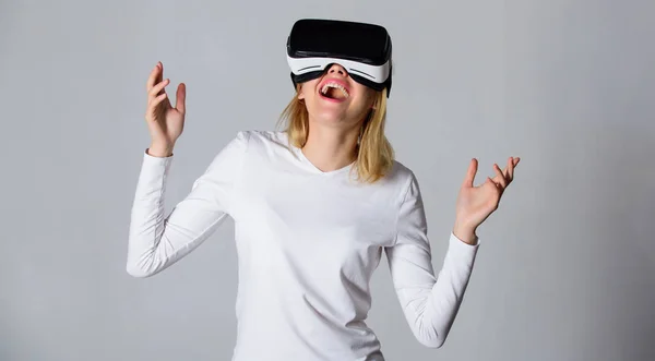 Woman with virtual reality headset. Portrait of an amazed girl using a virtual reality headset isolated on grey background. Funny young woman with VR. Woman VR.