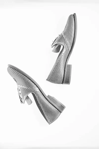 分離した、白地に銀の革で作った靴。女性の靴のコンセプトです。穿孔フラット唯一の女性のためのシューズ。おしゃれな快適なローファー靴、トップ ビュー — ストック写真