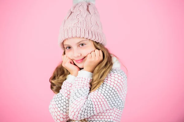 Criança cabelo longo chapéu de lã quente desfrutar de calor e maciez. Menina criança usar tricotado chapéu quente relaxante fundo rosa. Acessórios quentes que o manterão aconchegante inverno. Moda de inverno roupas quentes concep — Fotografia de Stock