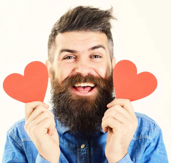 Чоловік з бородою з щасливим обличчям тримає червоні серця — стокове фото