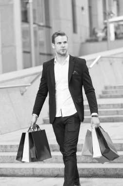 Lüks alışveriş. Butik Galeri istemci. Adam alışveriş alışveriş torbaları kentsel arka plan taşır. Başarılı bir iş adamı sadece lüks markalar ve yüksek moda butiklerinde alışveriş tercih