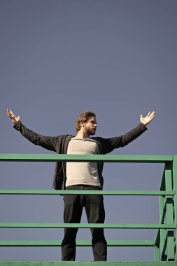 Açık elli adam, güneşli mavi gökyüzünde yüksekte duruyor. Özgürlük, başarı konsepti