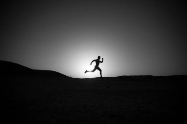 adam siluet günbatımı gökyüzüne çalıştıran