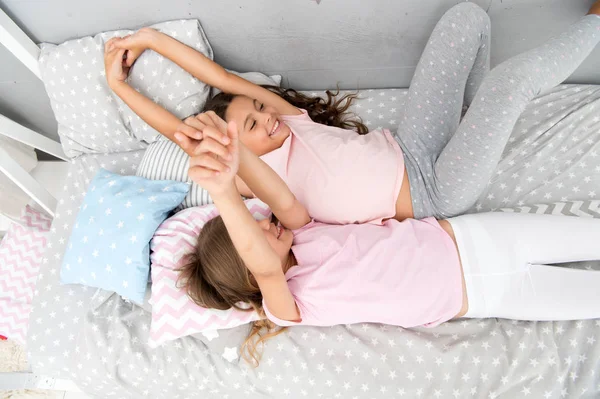 Friendship of small girls. Leisure and fun. Having fun with best friend. Children playful cheerful mood having fun together. Pajama party and friendship. Sisters happy small kids relaxing in bedroom — Stock Photo, Image
