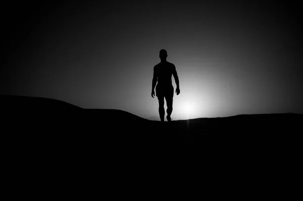 Férfi séta napnyugtakor ég háttere. — Stock Fotó
