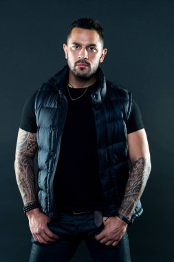 Acımasız sıkı maço dövmeleri olan. Erkeklik ve vahşeti. Dövme kültür kavramı. Dövme acımasız özniteliği. Adam acımasız tıraşsız İspanyol görünüm silah dövme. Sakallı adam dövmeler ile poz