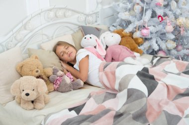 Noel rüyalar. Çocuk uyuyor. Noel ağacı, küçük bir çocuk uyku. Küçük kız oyuncakları ile yatakta yalan. Sevimli kız Noel geceden sonra uykuya daldı. Huzurlu uyku ve dinlenme kış tatil günleri